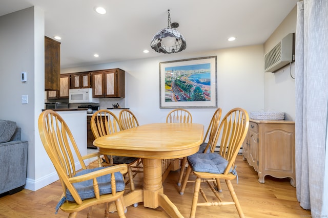 dining area featuring light wood-type flooring and a wall mounted AC