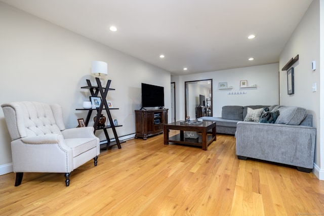 living room with baseboard heating and light hardwood / wood-style floors