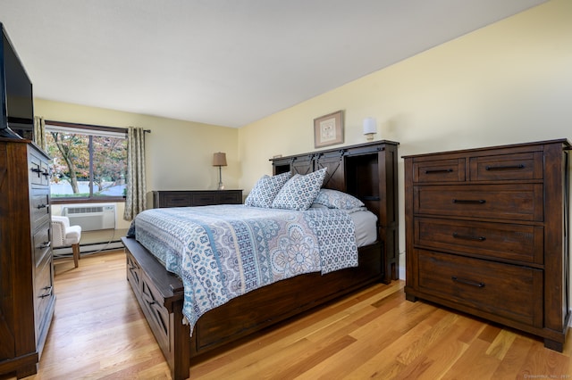 bedroom featuring baseboard heating and light hardwood / wood-style flooring