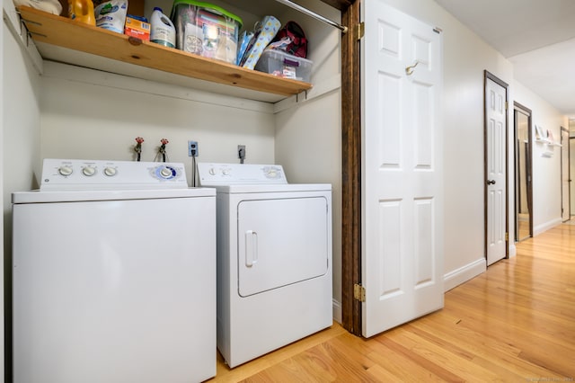 laundry room featuring washer and clothes dryer and light hardwood / wood-style flooring