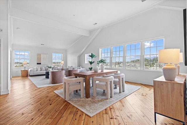 dining room with light hardwood / wood-style flooring, beamed ceiling, high vaulted ceiling, and ornamental molding