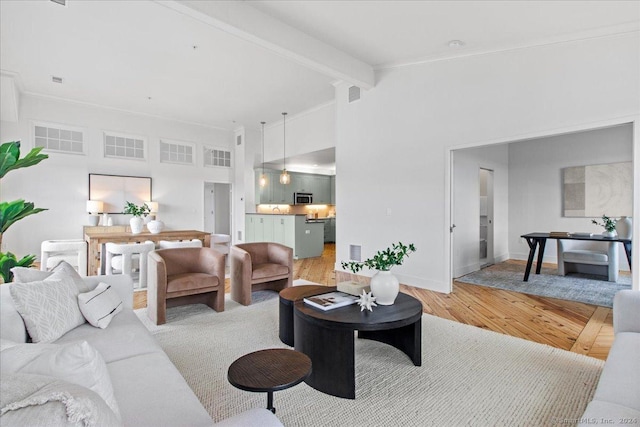 living room with hardwood / wood-style flooring and vaulted ceiling with beams