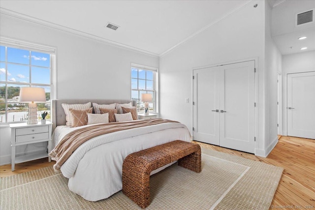 bedroom with hardwood / wood-style flooring, vaulted ceiling, and ornamental molding