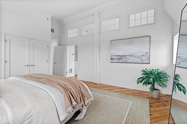 bedroom featuring wood-type flooring and crown molding