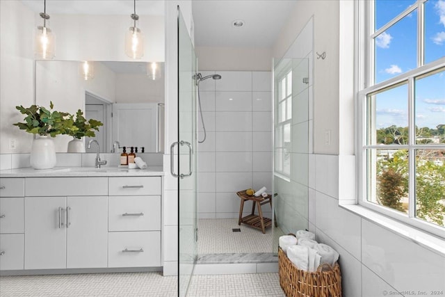 bathroom with vanity, tile patterned floors, tile walls, and a shower with shower door