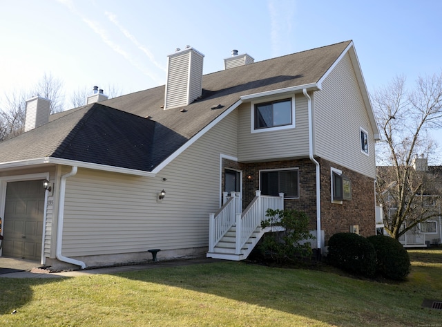 rear view of house with a garage and a lawn