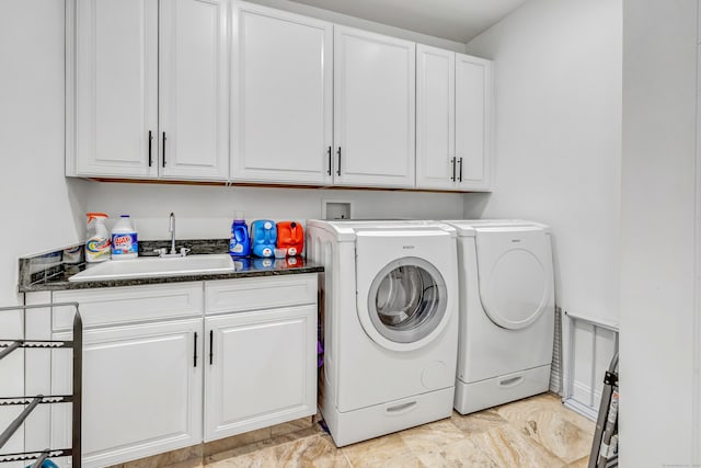 washroom with sink, independent washer and dryer, and cabinets