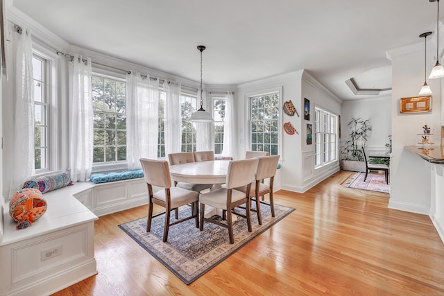 dining area featuring light hardwood / wood-style flooring, crown molding, and a wealth of natural light