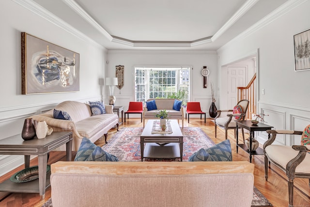 living room featuring light parquet flooring, ornamental molding, and a tray ceiling