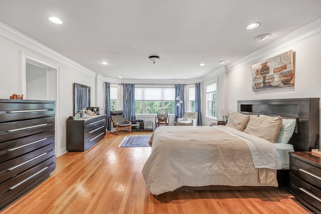 bedroom with crown molding and light hardwood / wood-style floors