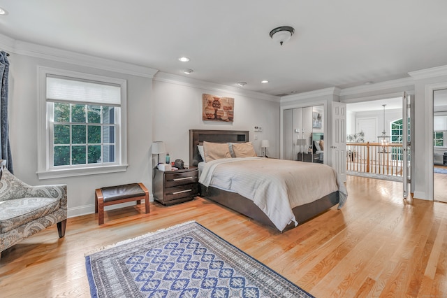 bedroom with light hardwood / wood-style flooring, crown molding, and multiple windows