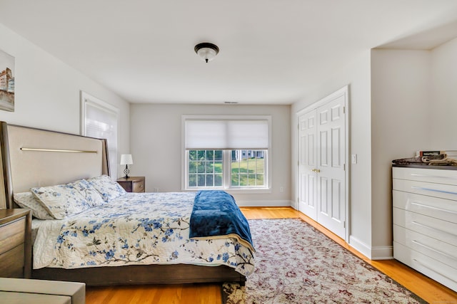 bedroom with light hardwood / wood-style flooring and a closet