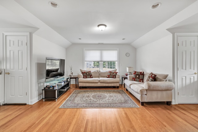 living room featuring vaulted ceiling and hardwood / wood-style flooring