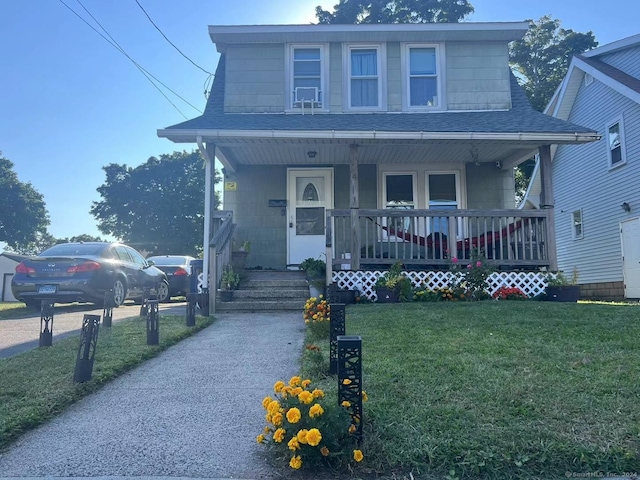 view of front of property featuring a front yard and covered porch