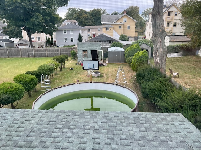 view of home's community featuring a lawn and a storage shed