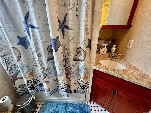 bathroom featuring tile walls, shower / tub combo with curtain, vanity, and tile patterned flooring