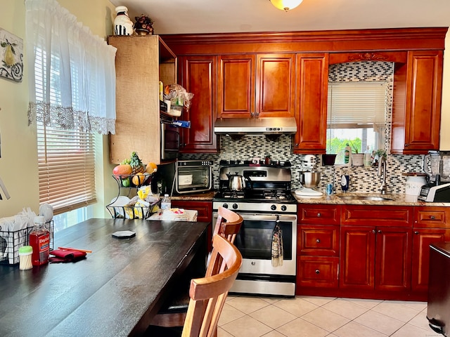 kitchen featuring decorative backsplash, stainless steel gas range, and plenty of natural light