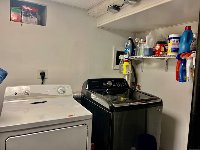 laundry room with separate washer and dryer and a textured ceiling