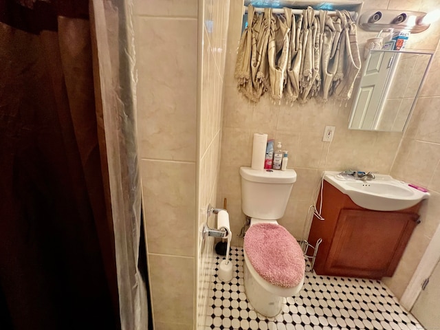 bathroom featuring tile walls, tile patterned flooring, vanity, and toilet