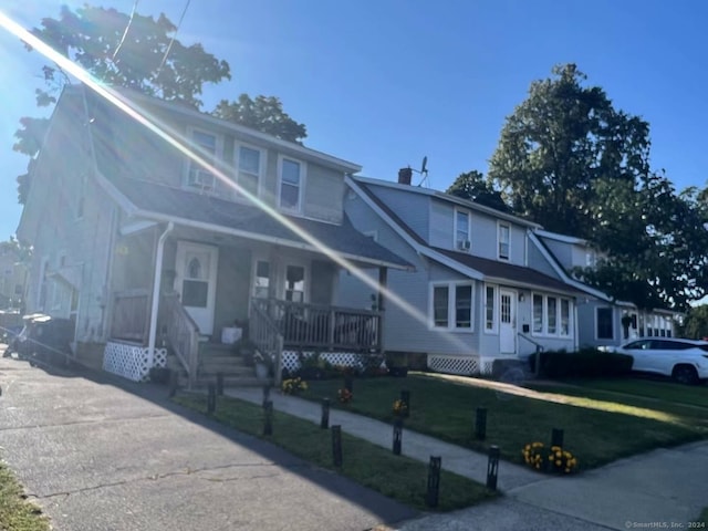 view of front facade featuring a front lawn and covered porch