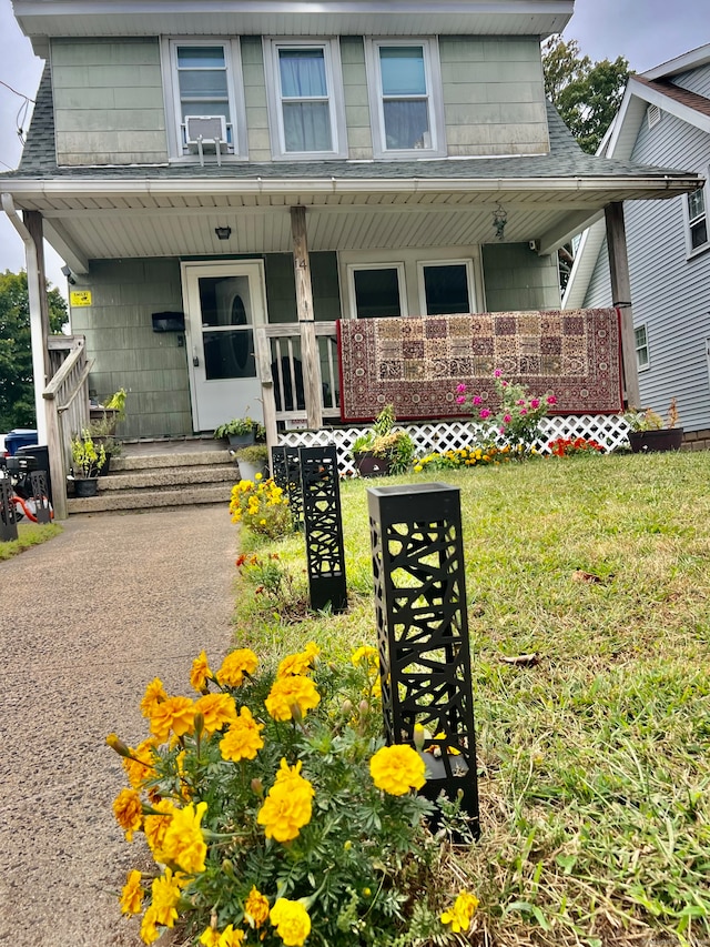 view of front facade featuring a front yard and covered porch