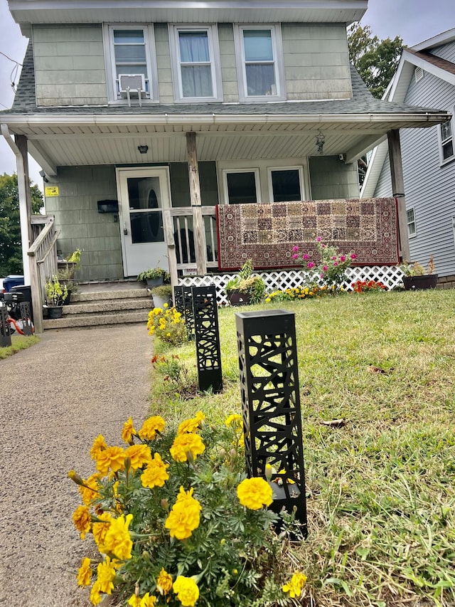 14 Bayview Pl, West Haven, CT 06516 - view of front facade featuring a porch, roof with shingles, and a front lawn