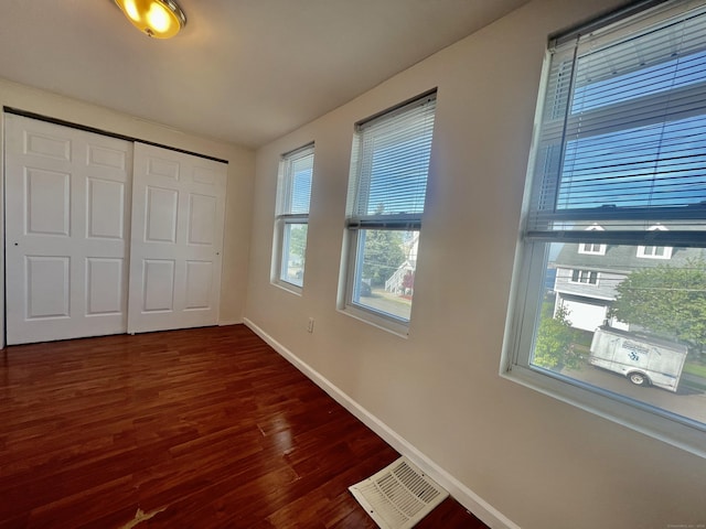 14 Bayview Pl, West Haven, CT 06516 - unfurnished bedroom featuring multiple windows, wood finished floors, baseboards, and a closet