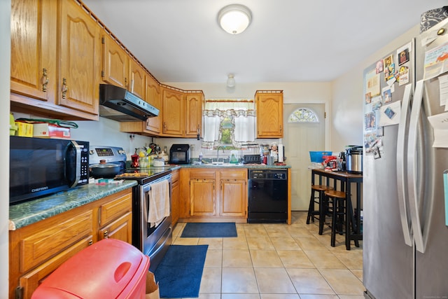 kitchen featuring black appliances, sink, and light tile patterned floors