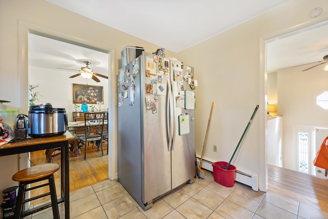 kitchen with light hardwood / wood-style floors, stainless steel fridge, and a baseboard heating unit