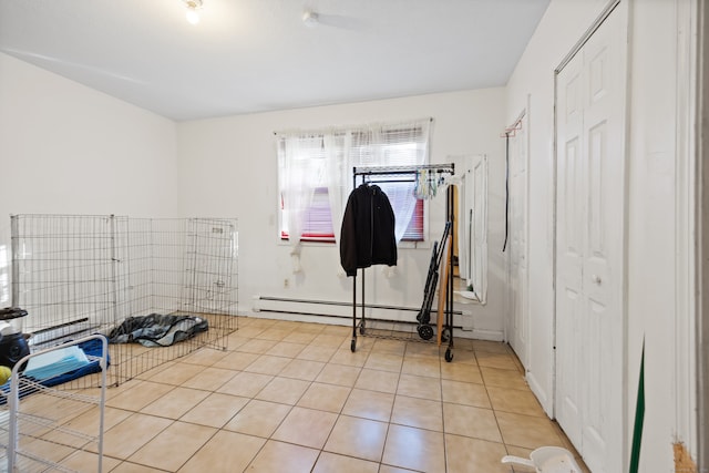 exercise room featuring light tile patterned floors and a baseboard heating unit