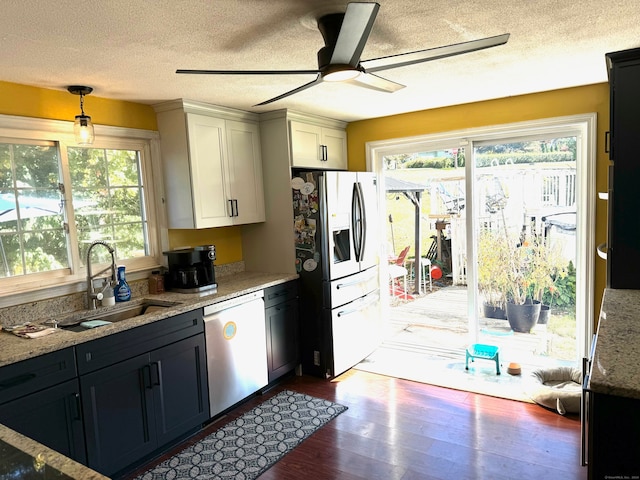 kitchen featuring a healthy amount of sunlight, dark hardwood / wood-style floors, stainless steel appliances, and decorative light fixtures