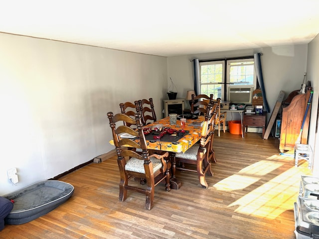 dining space featuring cooling unit and hardwood / wood-style floors