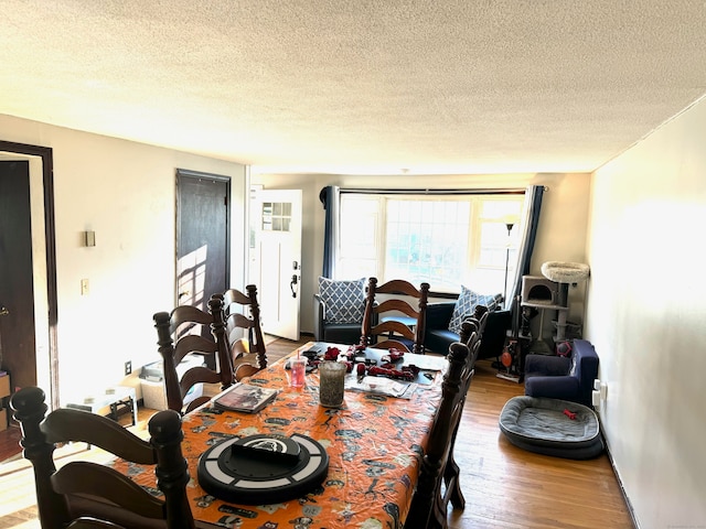 dining area with hardwood / wood-style flooring and a textured ceiling