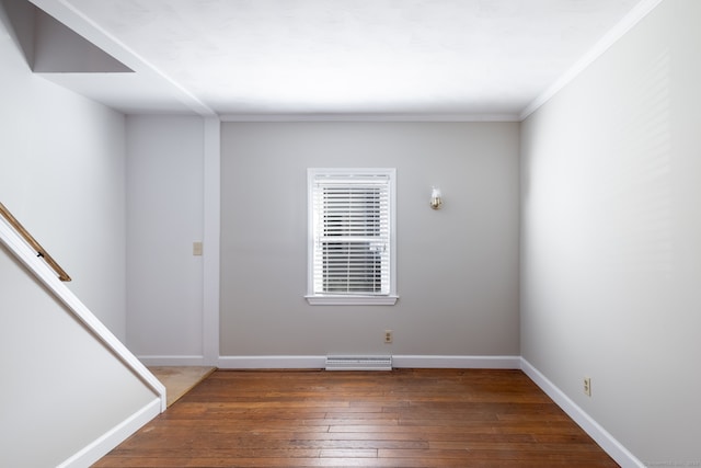 empty room with crown molding and dark hardwood / wood-style flooring