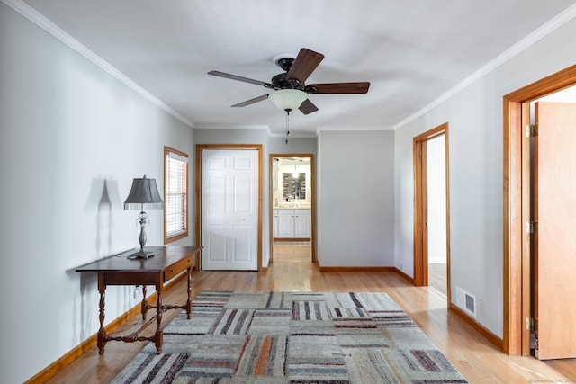 foyer entrance featuring crown molding, light hardwood / wood-style flooring, and ceiling fan