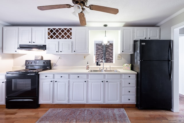 kitchen featuring crown molding, white cabinets, black appliances, and sink