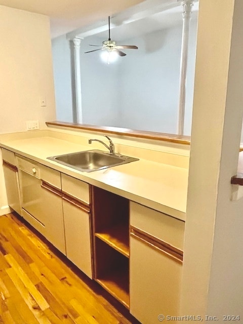 kitchen with light wood-type flooring, ceiling fan, and sink