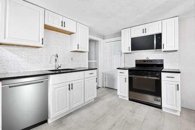 kitchen with a textured ceiling, tasteful backsplash, sink, white cabinetry, and stainless steel appliances