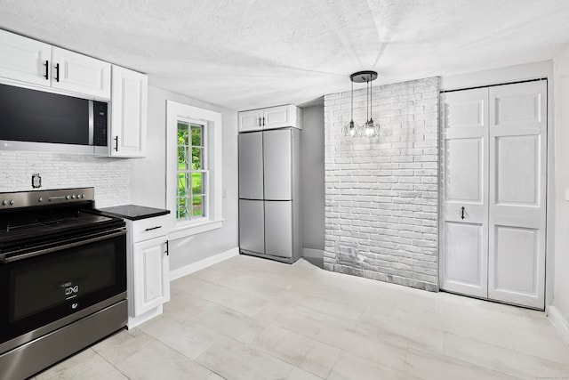 kitchen featuring pendant lighting, white cabinets, a textured ceiling, and appliances with stainless steel finishes