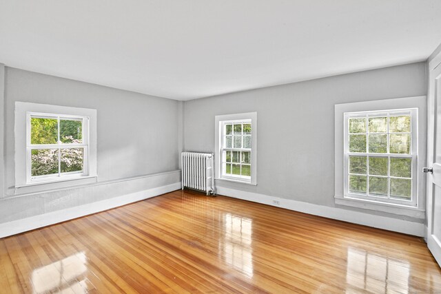 empty room featuring light wood-type flooring and radiator