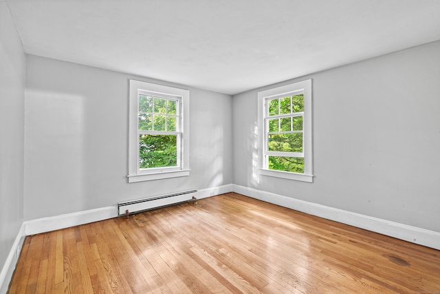 spare room featuring light wood-type flooring and a baseboard heating unit