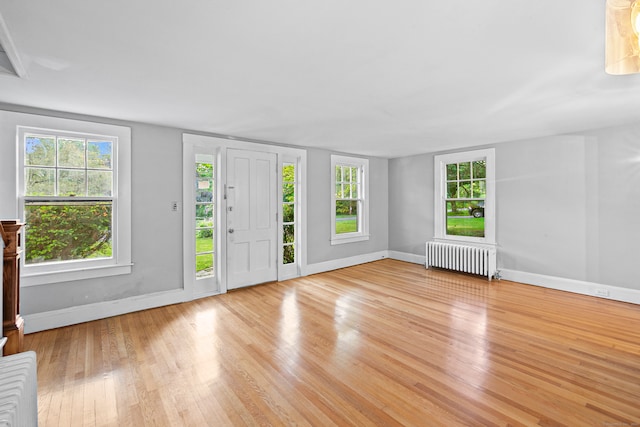 entrance foyer with light wood-type flooring and radiator heating unit