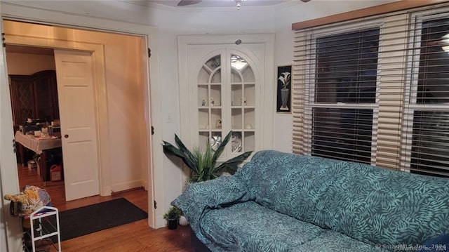 living area with wood-type flooring and crown molding