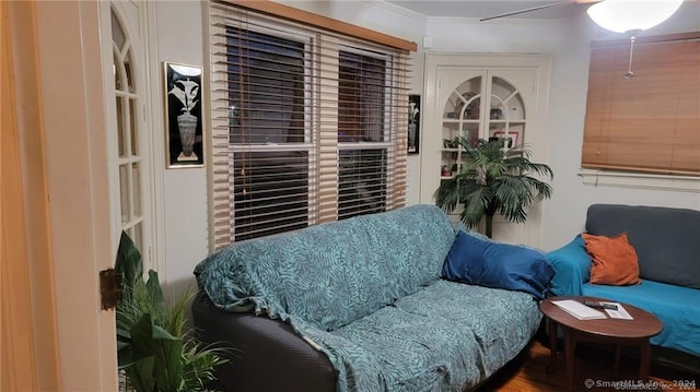 sitting room with wood-type flooring, ceiling fan, and ornamental molding