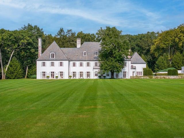 rear view of house featuring a yard