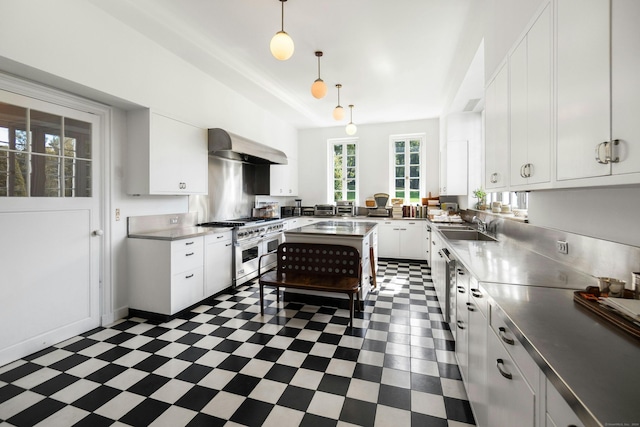 kitchen featuring hanging light fixtures, sink, white cabinetry, exhaust hood, and range with two ovens