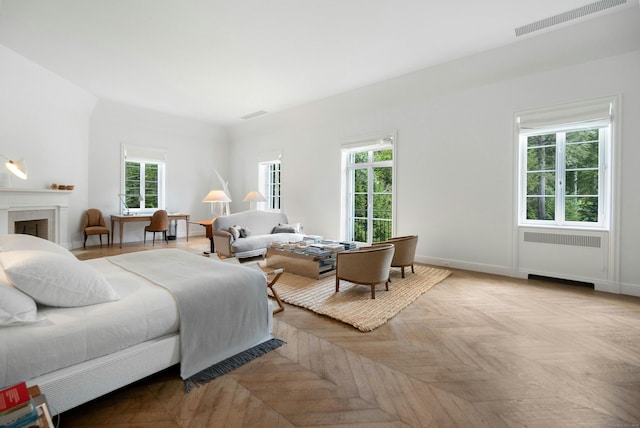 bedroom featuring radiator heating unit and light parquet flooring