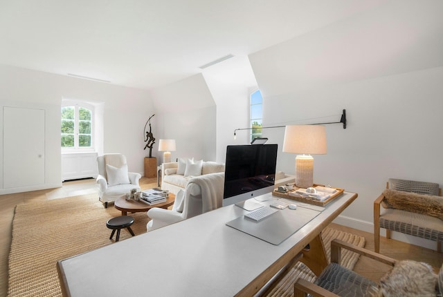 office area featuring light wood-type flooring and vaulted ceiling