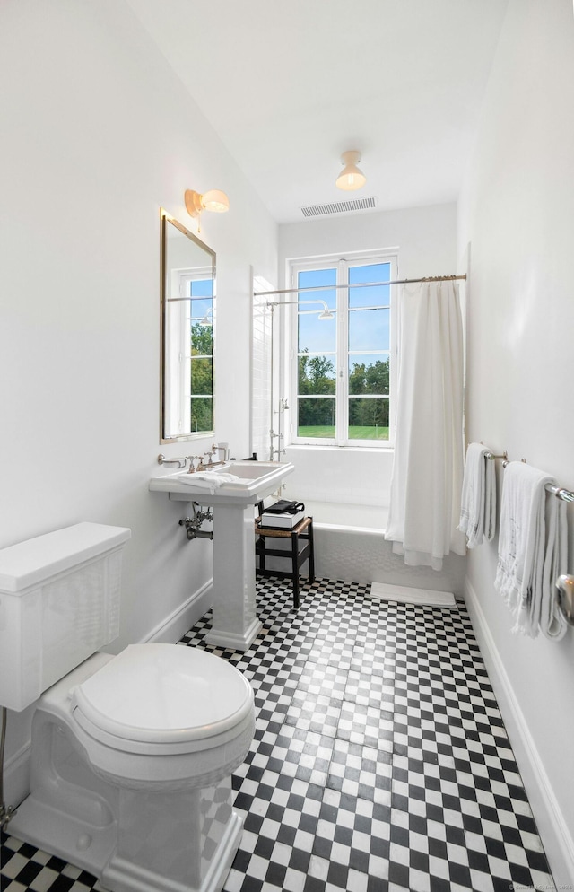 bathroom featuring separate shower and tub, toilet, and a healthy amount of sunlight