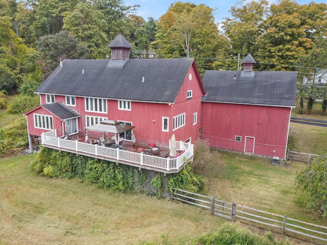 back of house with a gazebo, an outdoor structure, a wooden deck, and a lawn